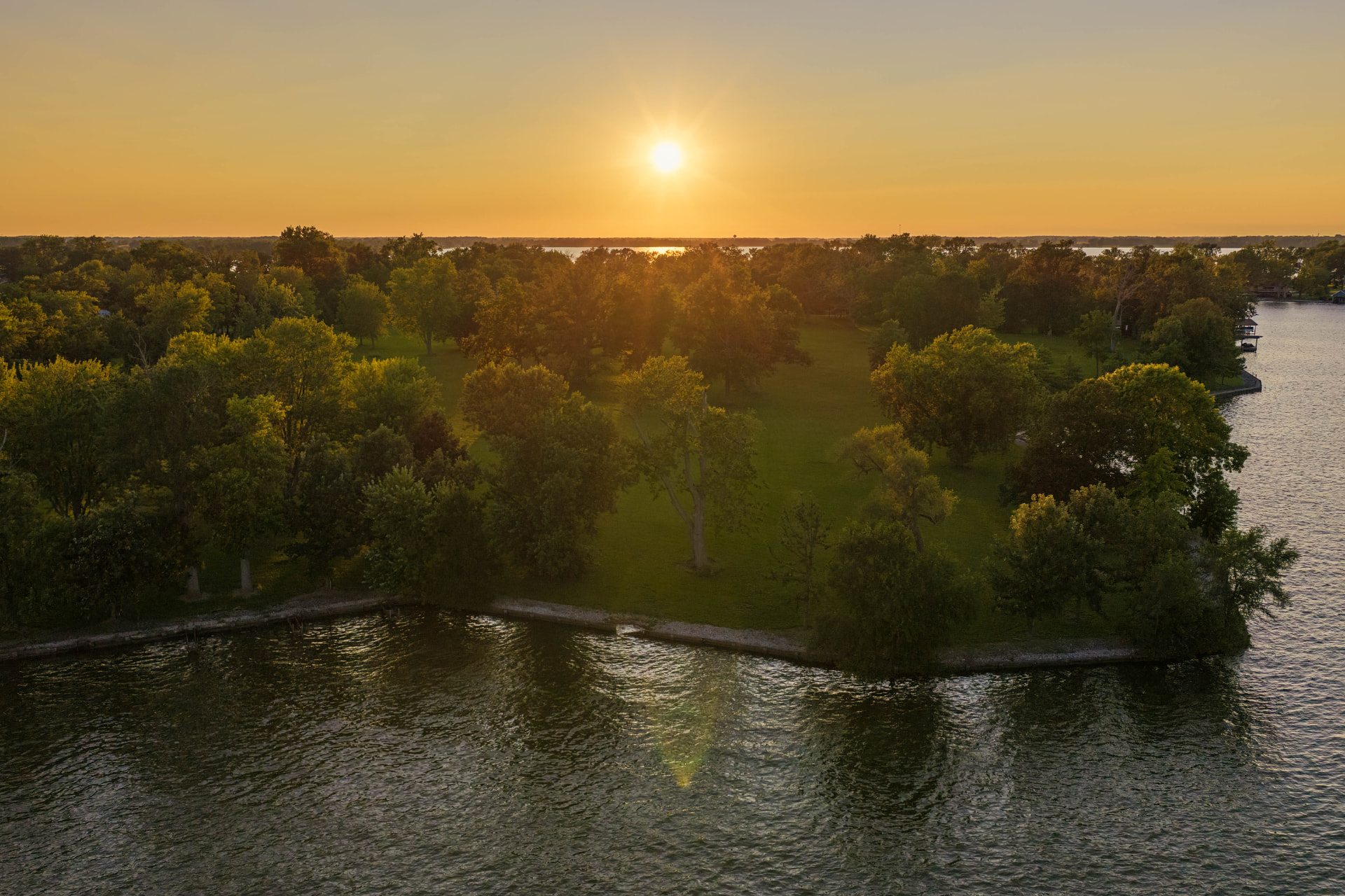 Aerial view of Orchard Island and its shoreline at sunset.